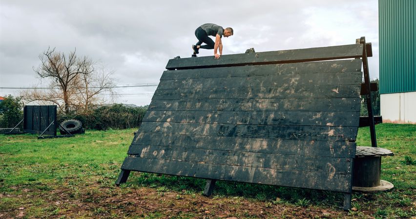 Participant in obstacle course climbing pyramid obstacle