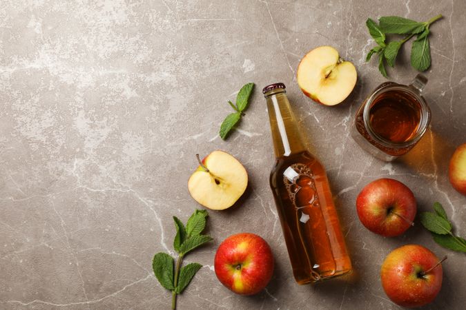 Composition with cider and apples on gray background