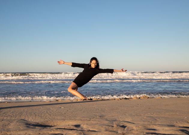 Woman with dancing near water on shore