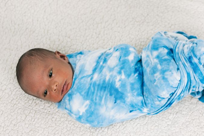 Newborn baby wrapped on soft blanket