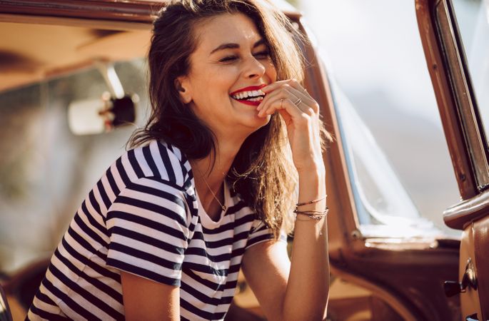 Woman smiling while sitting in a vintage car
