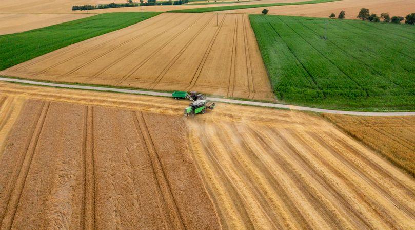 Drone shot with a combine harvesting crop in Germany in the evening