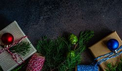 Christmas holiday concept with top view of gifts, baubles and branch