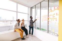 Colleagues working with sticky notes in a bright modern office