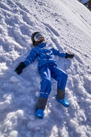 Happy boy making snow angel