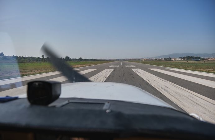 Modern airplane driving along runway under blue sky
