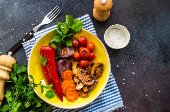 Plate of grilled vegetable on striped blue napkin with space for text