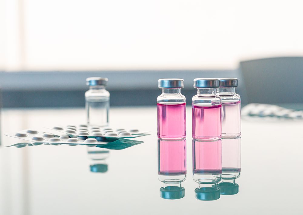 Vials with scientific samples arranged on glass table