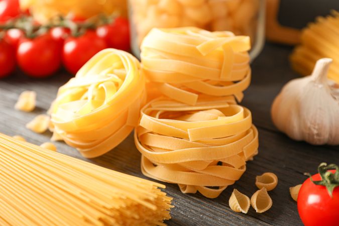 Composition with pasta cooking ingredients on wooden table, space for text and closeup