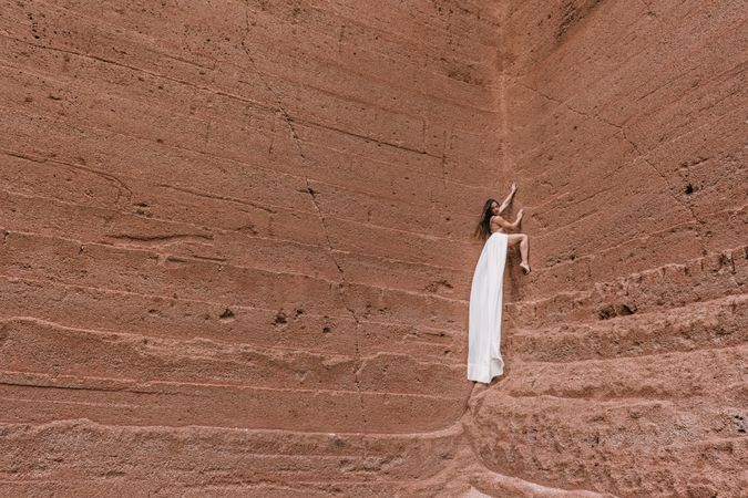 Elegant female posing on rocky cliff