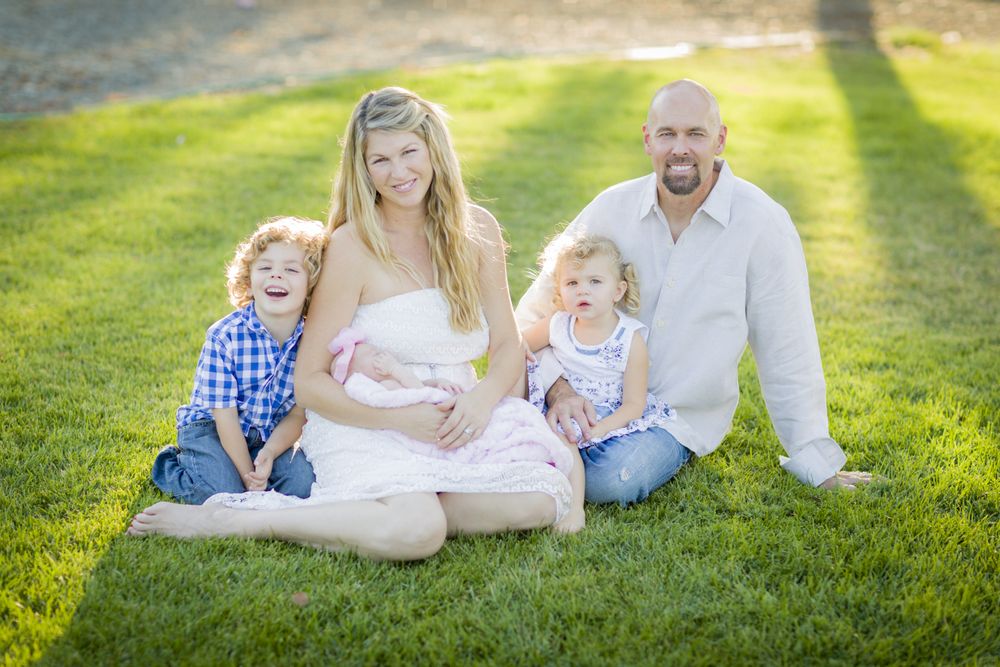 Happy Young Family Portrait Outside on Grass