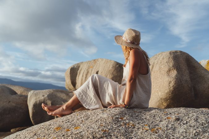 Carefree woman enjoying rest on coast near cliffs