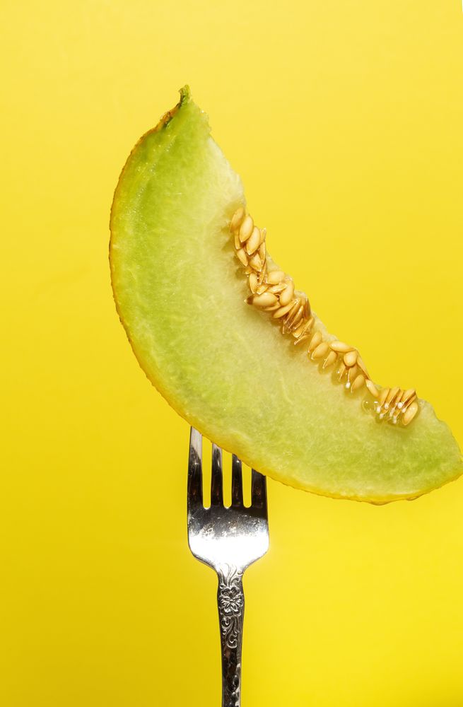 Piece of melon strung on shiny fork