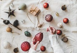 Flat-lay of holiday decoration, with hands and string, top view
