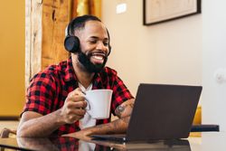 Black man teleworking with laptop from home