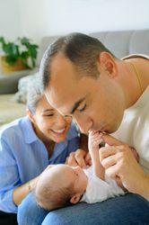 Happy parents communicating with infant in living room