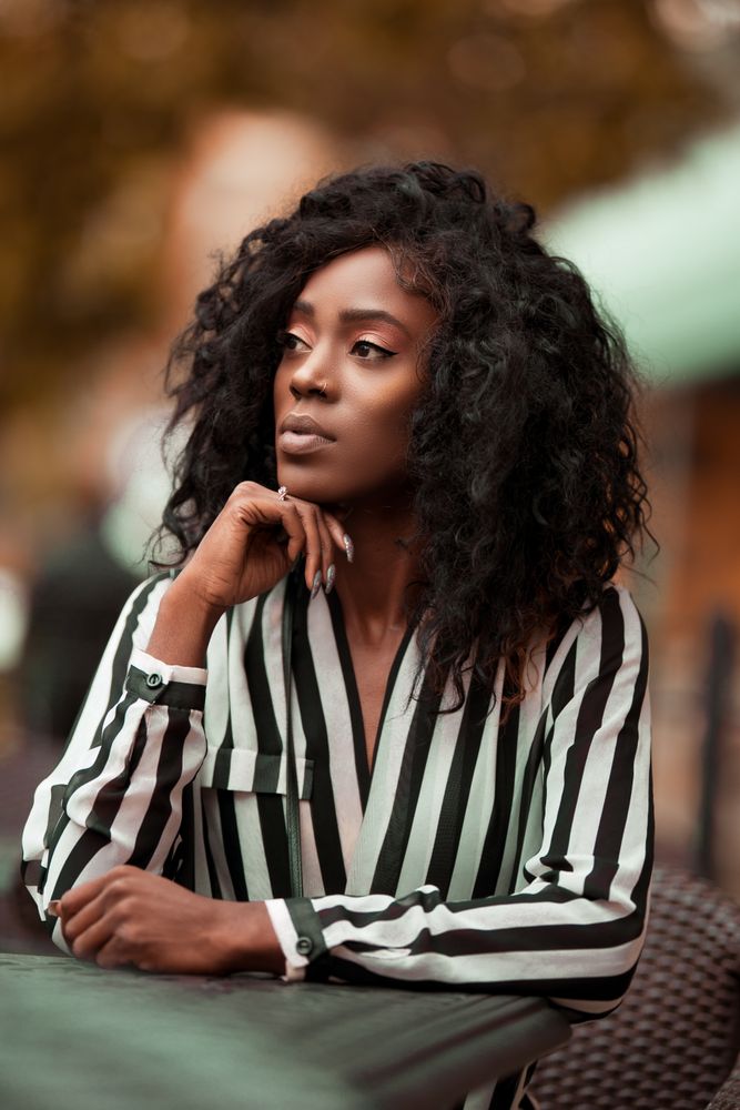 Portrait of woman with curly hair wearing striped top