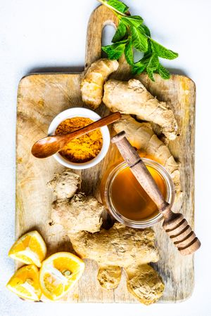 Top view of raw ginger, turmeric & honey on cutting board