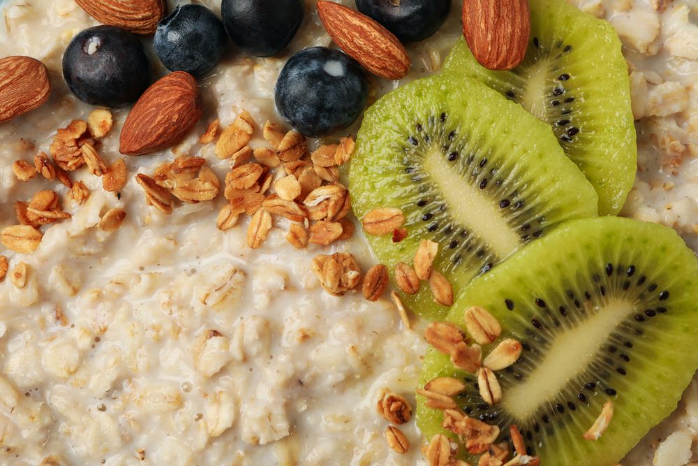 Oatmeal porridge with fruits on whole background, close up