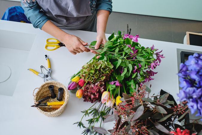 Unrecognizable female florist arranging bouquet of flowers