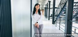 Businesswoman smiling while standing in a creative workplace 5QAwN5