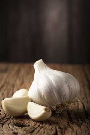 Garlic bulb and garlic cloves on the wooden table.