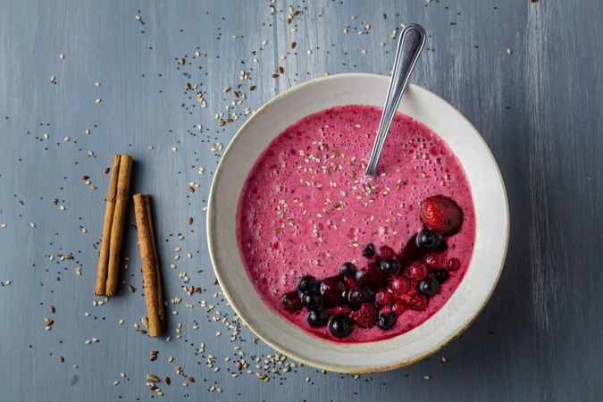 Smoothie bowl with fresh berries and sesame served on table