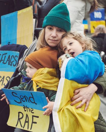 London, England, United Kingdom - March 5 2022: Woman and children in Ukrainian flag at protest