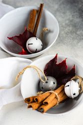 Winter table setting of cinnamon sticks in bowls with ornaments