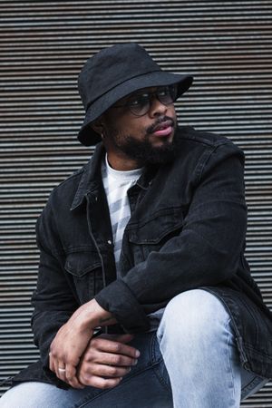 Black hipster man in hat looking at camera