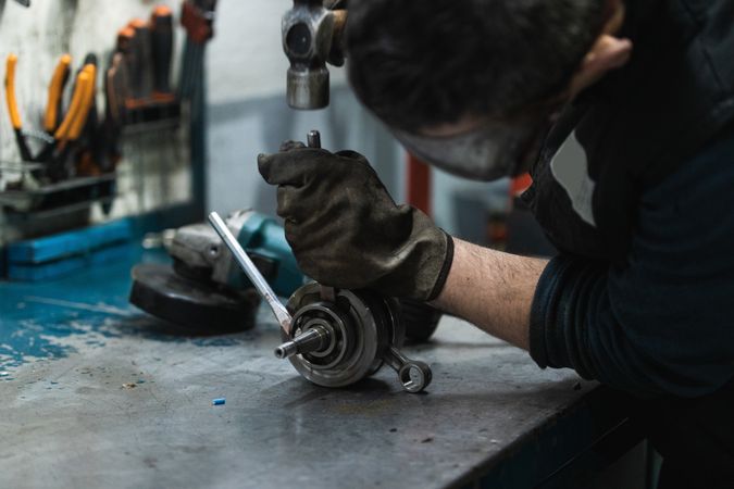 Focused workman repairing crankshaft bearing in garage
