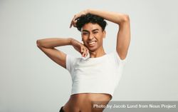 Portrait of a man wearing crop top winking at camera 0vGO75
