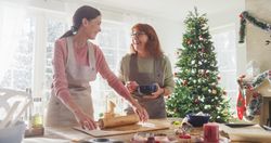 Portrait of Adult Woman Preparing Gingerbread for Christmas While her Mature Mother is Helping.