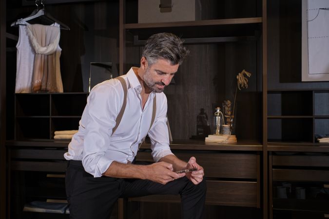 Man in elegant outfit browsing social media on smartphone