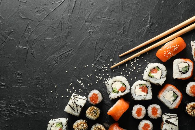 Delicious sushi rolls on dark background, top view. Japanese food