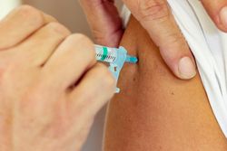 Person getting vaccinated by healthcare worker