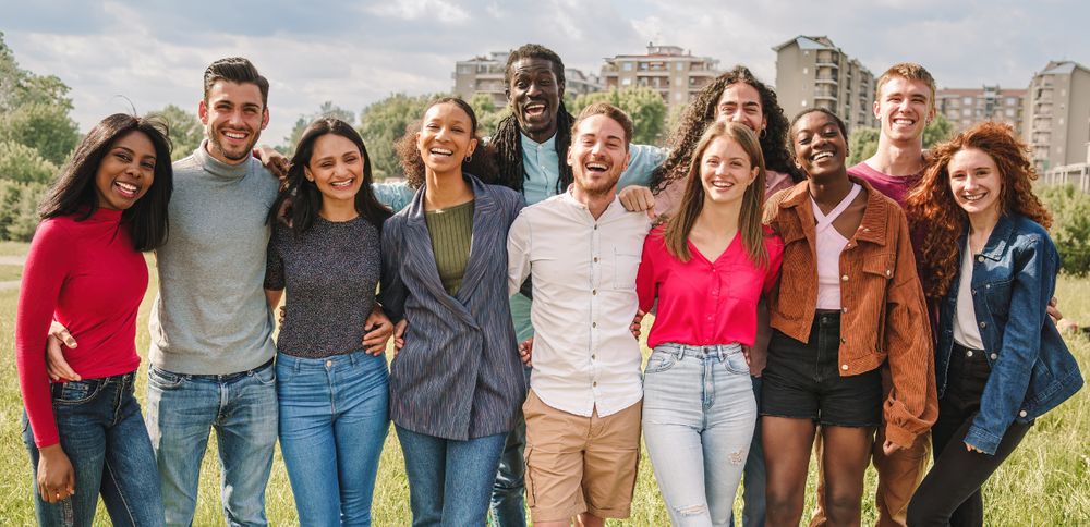Large group of multiethnic friends posing together outdoors and looking at camera