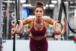 Sporty woman on gymnastic hoops at gym