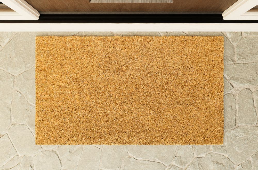 Overhead of blank doormat on the porch at the front door.