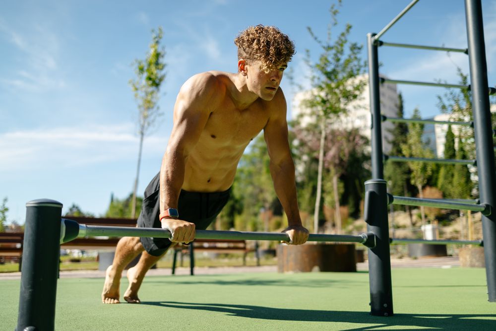 Strong young sportsman doing calisthenics