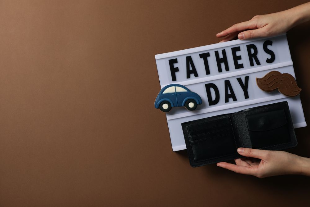 Inscription on a chalkboard father's day, on a brown background, with gifts.