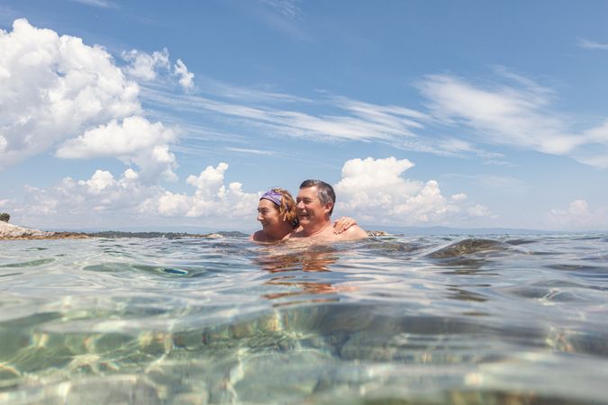 Mature couple swimming together in fresh water