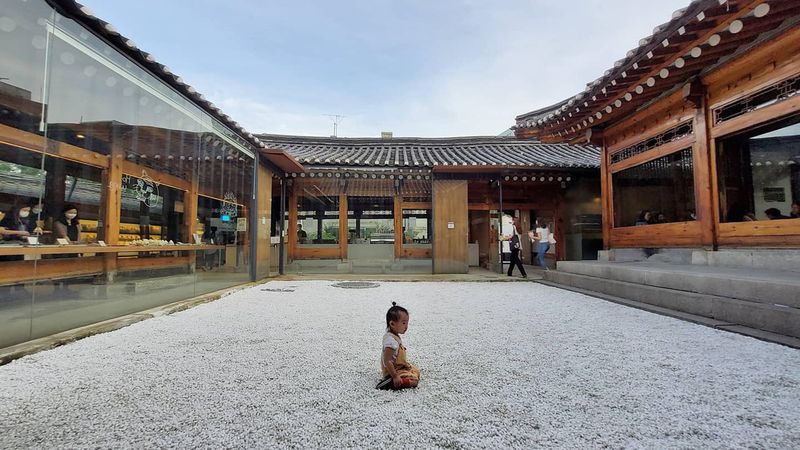 Child sitting on floor outside Japanese style building