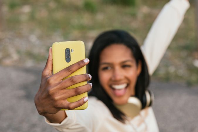 Woman on longboard taking selfie on smartphone