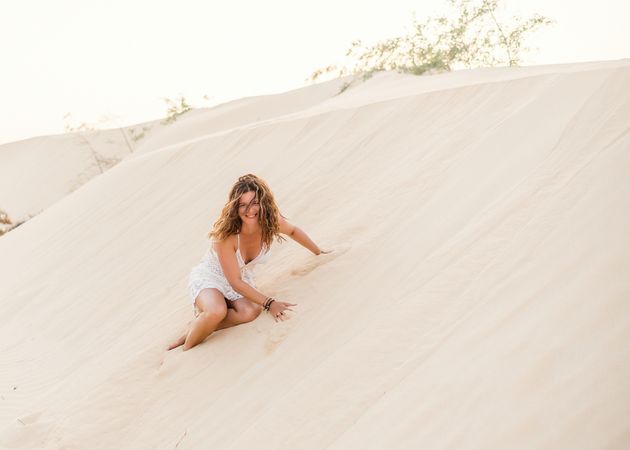 Woman sitting on sand in desert