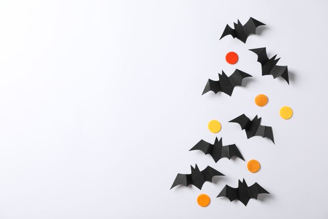 Decorative bats and color circles on plain background, copy space