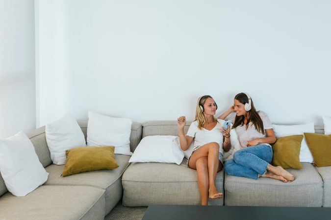 Delighted women singing on couch