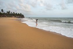 Woman in beachwear walking on sand barefoot