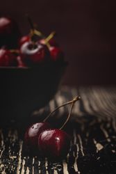 Juicy red cherry in bowl on rustic surface