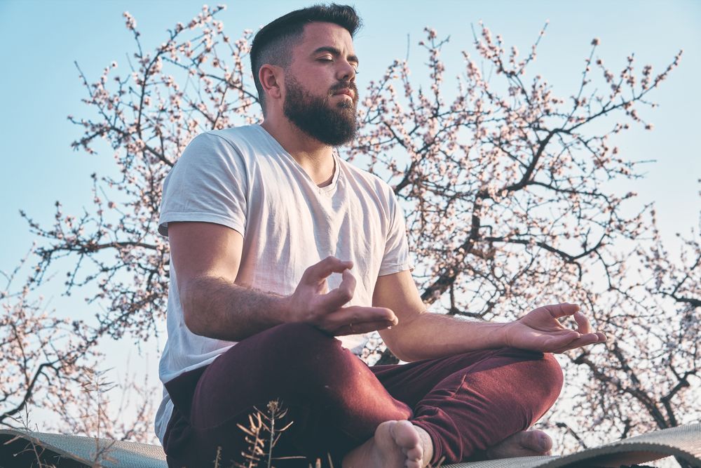 Bearded man meditating in spring garden